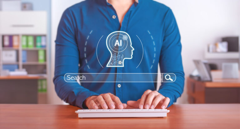 A person in a blue shirt types on a keyboard, with a digital AI icon and a search bar graphic overlayed in front of them, suggesting the use of AI-powered search technology to help small businesses improve local SEO.