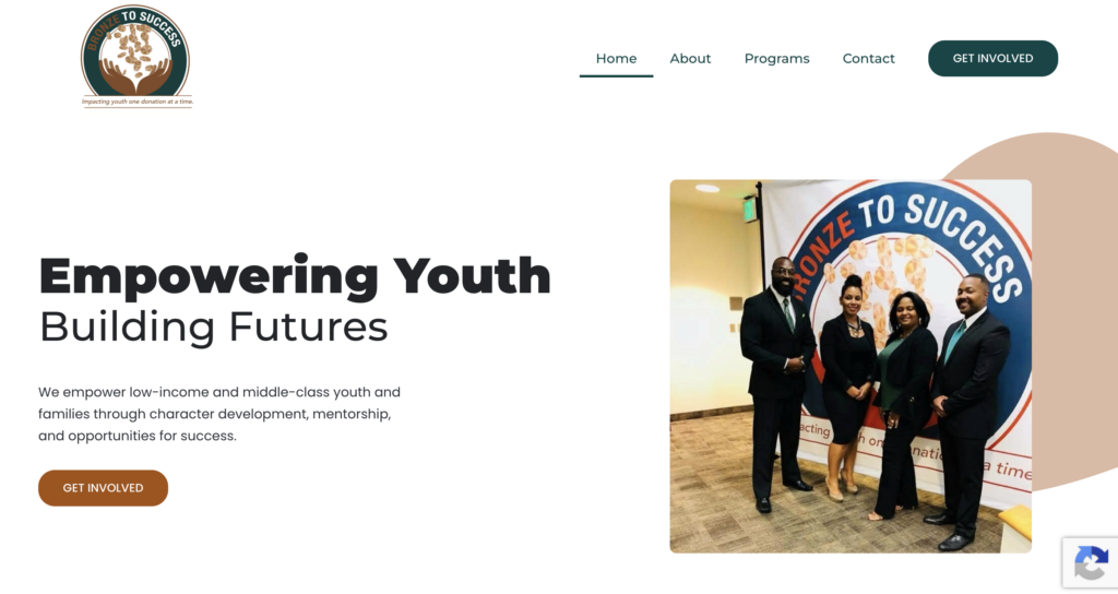 A group of four people in formal attire stands and smiles for a photo in front of a “TO SUCCESS” banner; the text reads “Empowering Youth, Building Futures.” This inspiring moment is featured in our Website Design Portfolio, showcasing our commitment to visually capturing impactful community events.